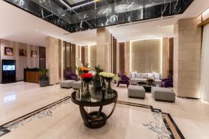 Lilac Park Hotel في تبوك: غرفة معيشة مع طاولة عليها زهور