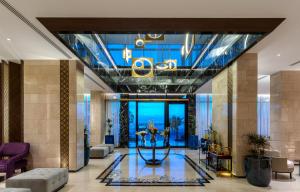 een lobby van een hotel met een blauw plafond bij Lilac Park Hotel in Tabuk