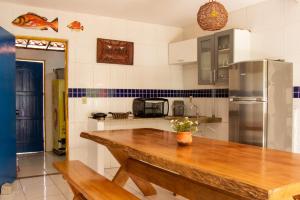 a kitchen with a wooden table and a refrigerator at casa preá in Cruz