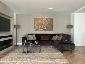 salon z czarną kanapą i stołem w obiekcie Jutphaas Loft Appartement w mieście Nieuwegein