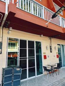 a table and chairs in front of a building at BeHome and Hostel in Chiang Mai