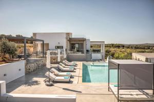 a villa with a swimming pool and lounge chairs at Skyline Villa in Angeliana