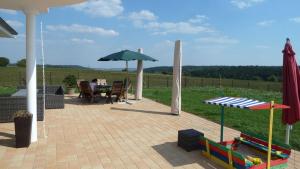 a person sitting at a table under an umbrella at Villa Toskana Rothenburg in Linden