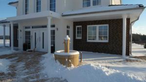 a yellow fire hydrant in the snow in front of a house at Villa Toskana Rothenburg in Linden