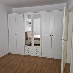 a bedroom with white cabinets and a bed at Ferienwohnung Rügen Breege in Breege