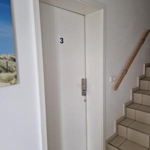 a door with the number three next to a staircase at Ferienwohnung Rügen Breege in Breege +5 photos