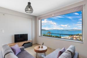 a living room with a large window with a view of the ocean at Amazing View Villa-Mathaios in Plaka -BY APOKORNAS VILLAS in Plaka