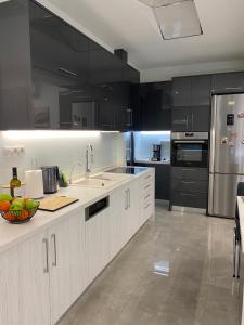 a kitchen with black cabinets and stainless steel appliances at Ivory Style Maisonette near Downtown in Heraklio