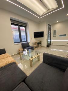 a living room with a couch and a tv at Ivory Style Maisonette near Downtown in Heraklio