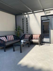 a patio with two couches and a table at Ivory Style Maisonette near Downtown in Heraklio