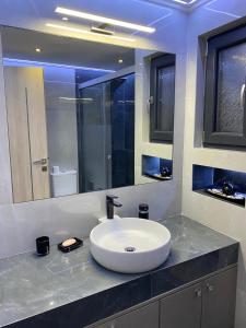 a bathroom with a sink and a large mirror at Ivory Style Maisonette near Downtown in Heraklio