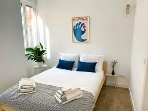 a bedroom with a large white bed with blue pillows at Casa Longa Faro Entire House - Plunge Pool and Terrace in Faro