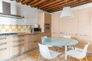 a kitchen with a glass table and white chairs at Ca' Mocenigo in Venice