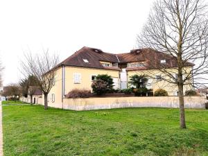 uma casa grande em um quintal com uma cerca em Les vergers de Serris, 6 personnes, 2 PK privés, balcon, lit bébé em Serris