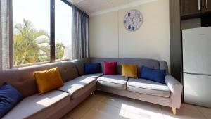 - un salon avec un canapé et des oreillers colorés dans l'établissement Breakers 324 by Top Destinations Rentals, à Durban