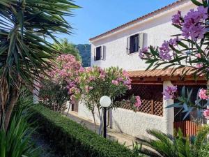 una casa con flores rosas delante de ella en Cottage84 - Proppro - Milazzo, en Milazzo