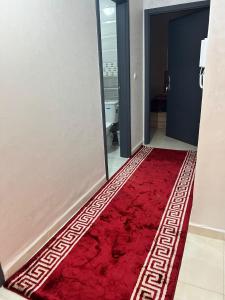 - un tapis rouge dans la salle de bains dans l'établissement شقق إقامة الامل, à Oulad Hamdane