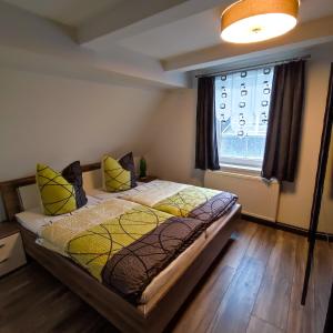Un dormitorio con una cama con almohadas amarillas y una ventana en Ferienwohnung am Markt in Olbernhau, en Olbernhau