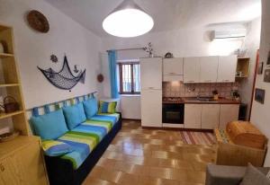 sala de estar con sofá azul y cocina en Cottage84 - Proppro - Milazzo, en Milazzo