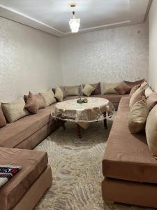 - un salon avec un canapé et une table dans l'établissement شقق إقامة الامل, à Oulad Hamdane