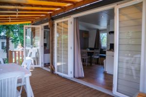 un porche cubierto con puertas correderas de cristal en Camping Parc Bellevue, en Cannes