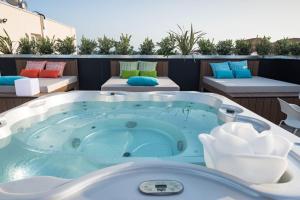 a jacuzzi tub on a balcony with two beds at Hotel La Contessa in Santa Teresa Gallura