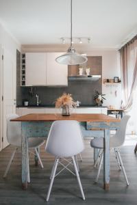 a kitchen with a wooden table and white chairs at Rossanella's Home in Desenzano del Garda