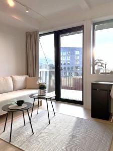 een woonkamer met een bank en een tafel bij Sleek 1BD Apt with Sea View in Tromsø