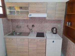 a small kitchen with a sink and a refrigerator at Paradise Studios in Liapades