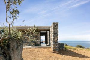 a stone house on a hill overlooking the ocean at Orizontes Villa, Tranquil SeaView Living, By ThinkVilla in Agios Pavlos
