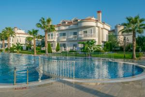 a large house with a swimming pool in front of a house at BlueHomes Villas in Belek