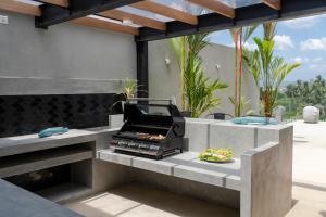 a barbecue grill on a patio with plants at The Nine, Mirissa in Mirissa