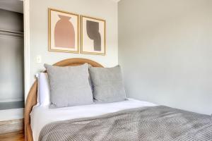 a bedroom with a bed with two pictures on the wall at Back Bay 1br w wd nr Newbury St BOS-725 in Boston