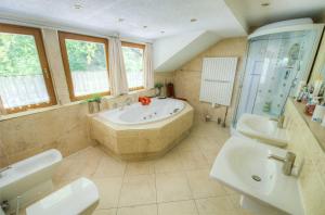 a large bathroom with a tub and a sink at Ferienhaus Jägerhaus Oppach Alleinlage mit See in Oppach