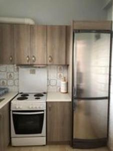 een keuken met een fornuis en een koelkast bij Naia Apartment in Sarandapikhiótika