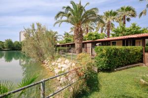 a house next to a lake with palm trees at Village Lake Placid in Silvi Marina