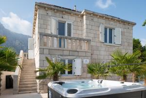 a house with a bath tub in front of it at Jakuzzi Vila Suartini Orebić in Orebić