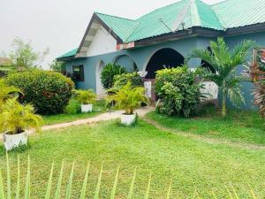 a house with a fence in front of a yard at HOMELY GUEST HOUSE in Agona