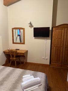 a bedroom with a bed and a desk and a television at La corte dell'ulivo in Polazzo