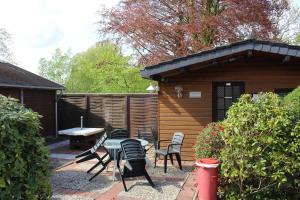 a patio with a table and chairs and a cabin at Seifert's Ferienwohnung Windrose 3 in Burhave in Burhave