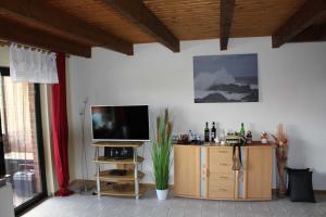 a living room with a television on a wooden cabinet at Seifert's Ferienwohnung Windrose 3 in Burhave in Burhave