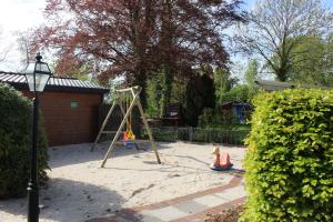 a playground with a swing set in a yard at Seifert's Ferienwohnung Windrose 3 in Burhave in Burhave
