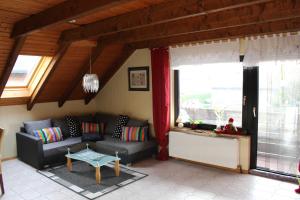 a living room with a couch and a table at Seifert's Ferienwohnung Windrose 3 in Burhave in Burhave