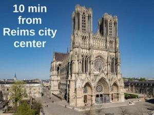 a large cathedral with the words min from returns city center at Santa Monica, maison spacieuse Reims Cormontreuil in Cormontreuil