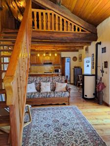 uma sala de estar com um sofá e uma escada em La casa nell'airetta em Balme