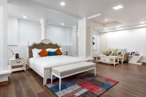 um quarto com uma grande cama branca e um sofá em Regenta Place Sabrina Kathmandu Nepal em Kathmandu