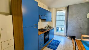 cocina con armarios azules y nevera azul en Fontana Home en Domodossola