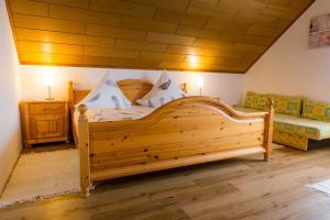 1 dormitorio con cama de madera y sofá en Haus Ohnemus Fam Späth, en Rust