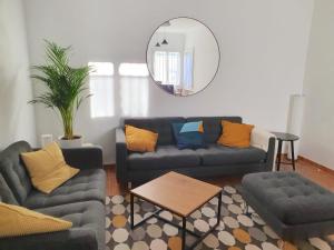 a living room with couches and a table and a mirror at Villa Tassigny in Aix-en-Provence
