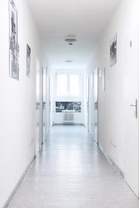 un pasillo vacío con paredes blancas y una ventana en Hostel na Šalamouně, en Ostrava